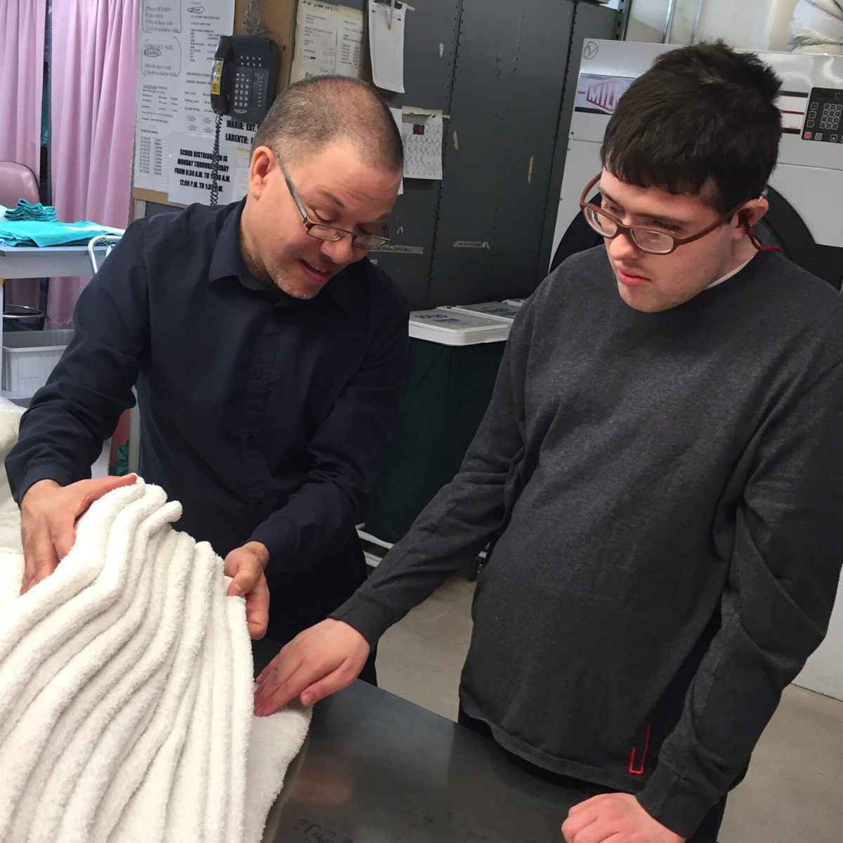 Jack folding towels with an adult.