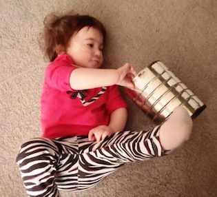 Child interacts with a metal can.