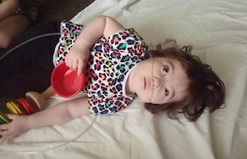 A child plays with a measuring cup.