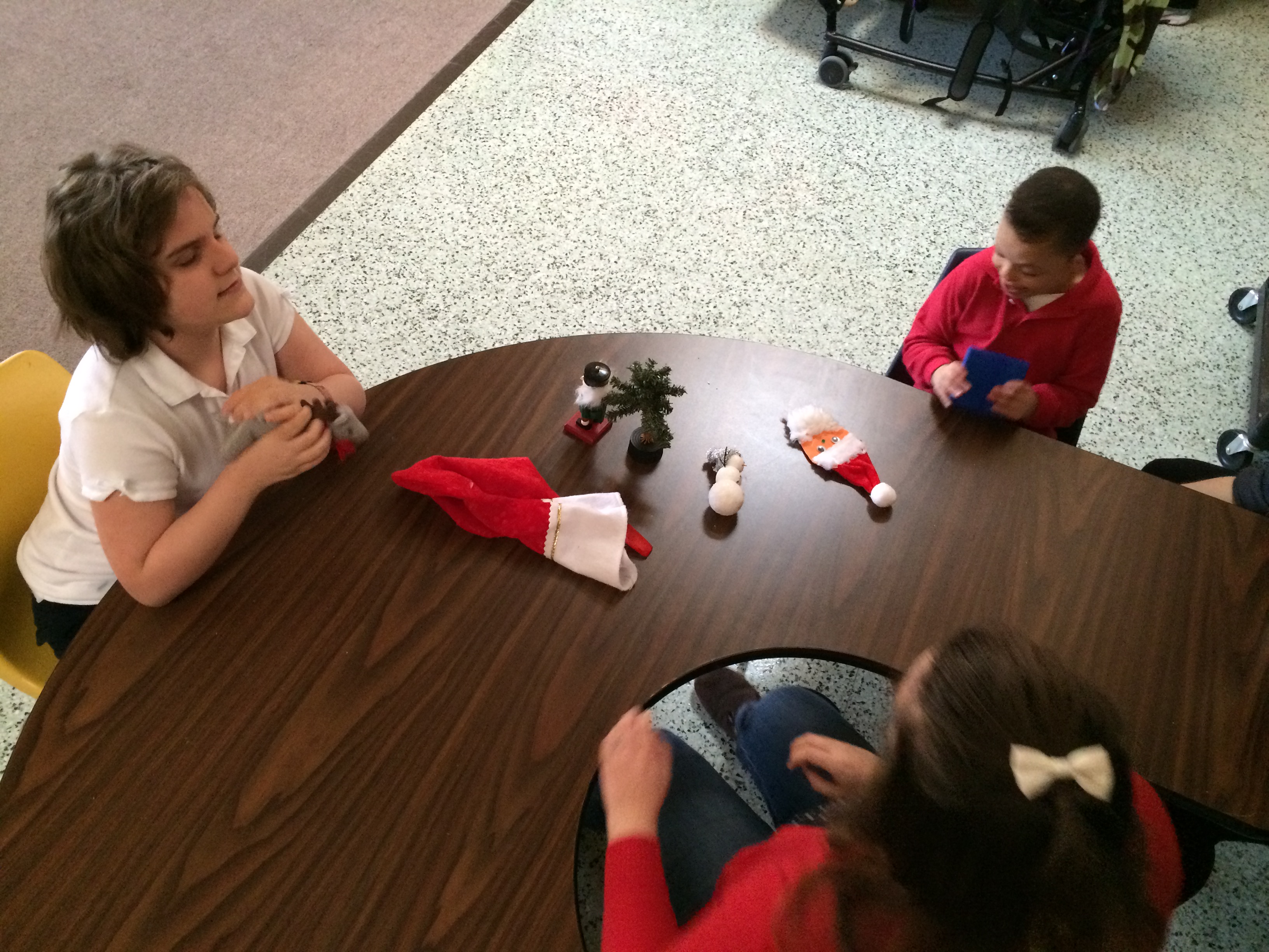 Three children play with toys at a table.